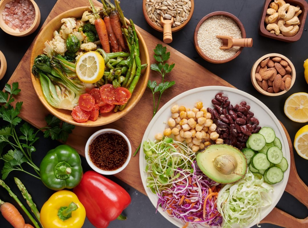 Vegan protein source. Buddha bowl dish, avocado, pepper, tomato, cucumber, red cabbage, chickpea, fresh lettuce salad and walnuts, nuts, beans, . Healthy vegetarian eating, super food. Top view.